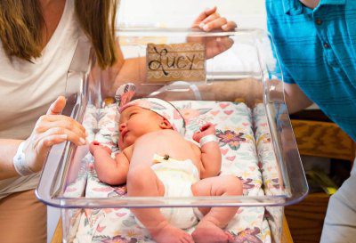 Parents look at an infant baby they are adopting