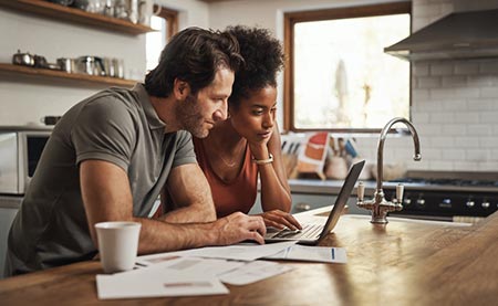 Couple looking at adoption loan paperwork in preparation of adopting