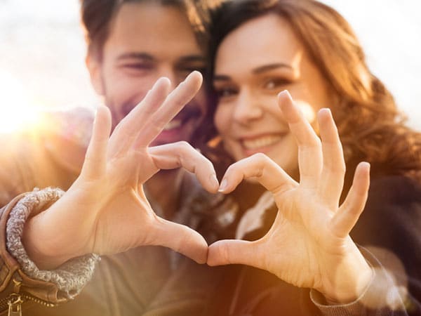 couple forming a heart with their hands